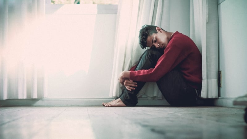 Man sitting in a corner of a room