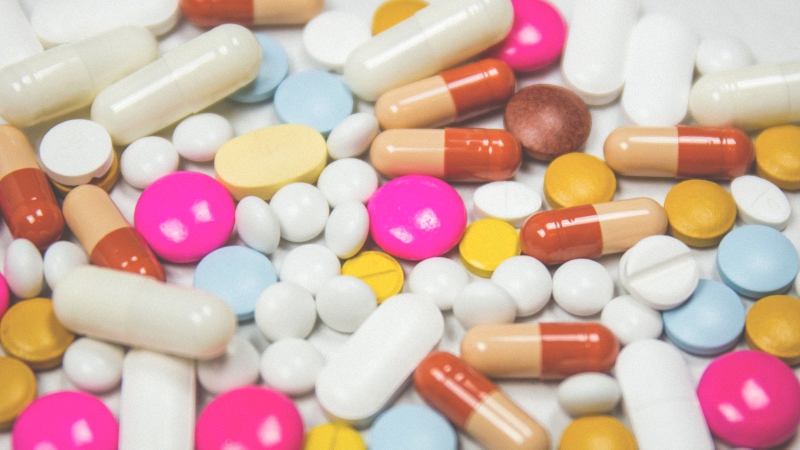 Multicolored medicinal pills lying on a white background