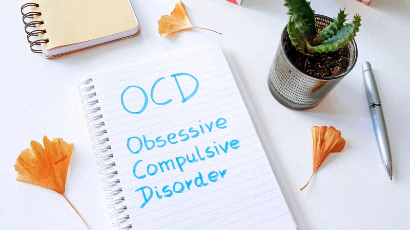 OCD written on a white piece of paper on a white desk