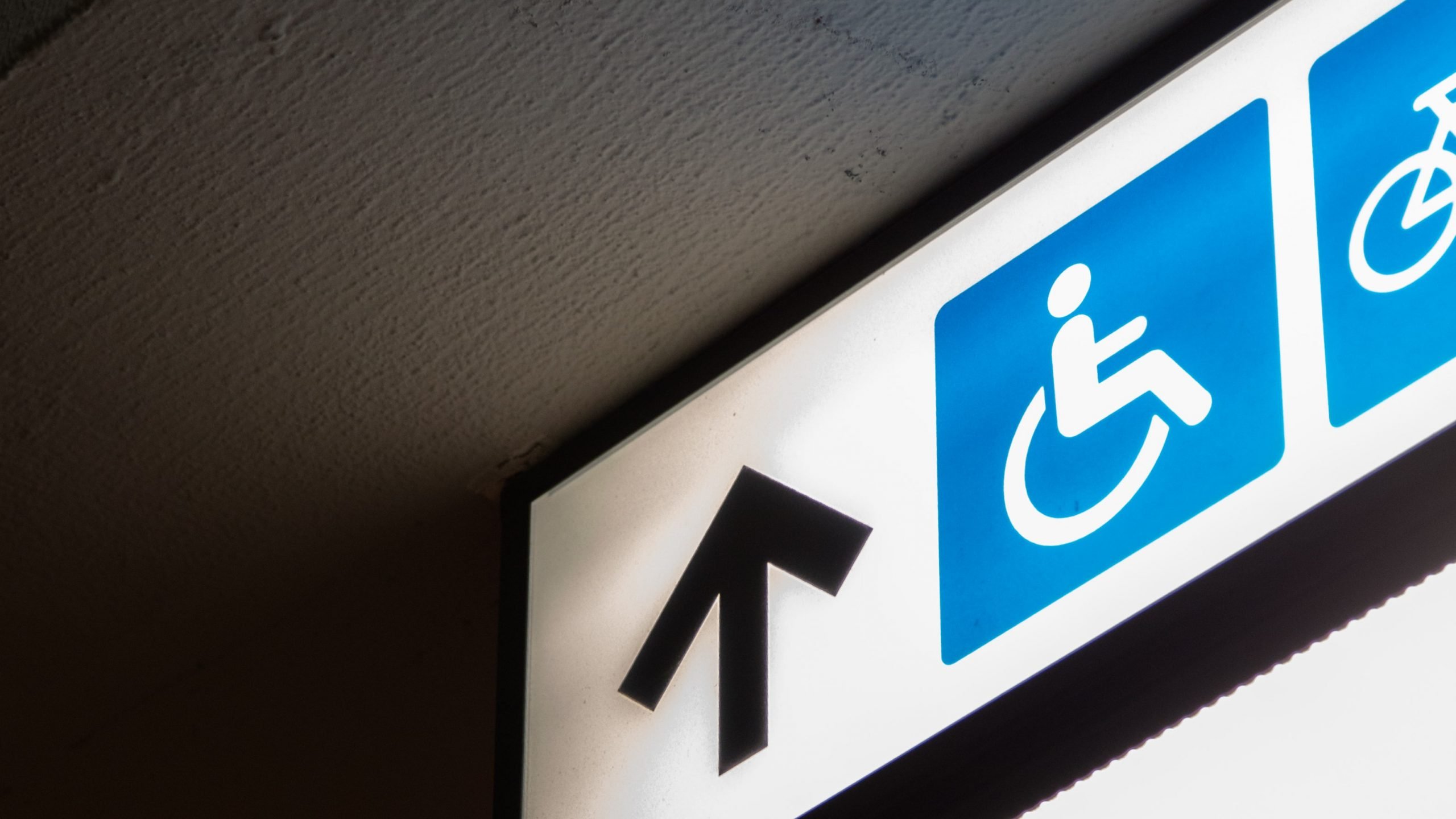 disabled sign on the ceiling with an arrow pointing upwards