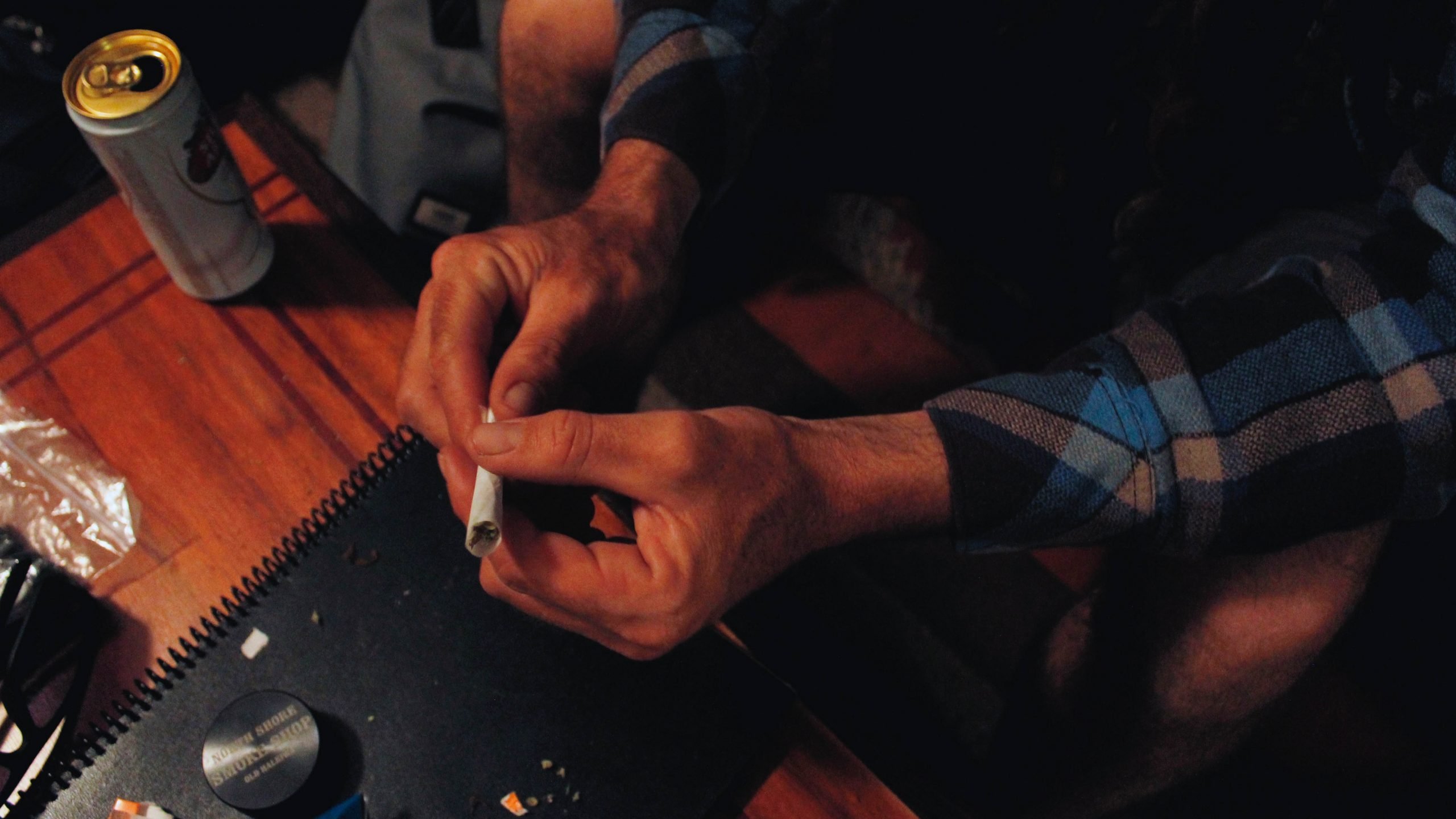 person rolling a paper joint on table