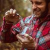 Man wearing a red button shirt smoking marijiuana from a glass bong