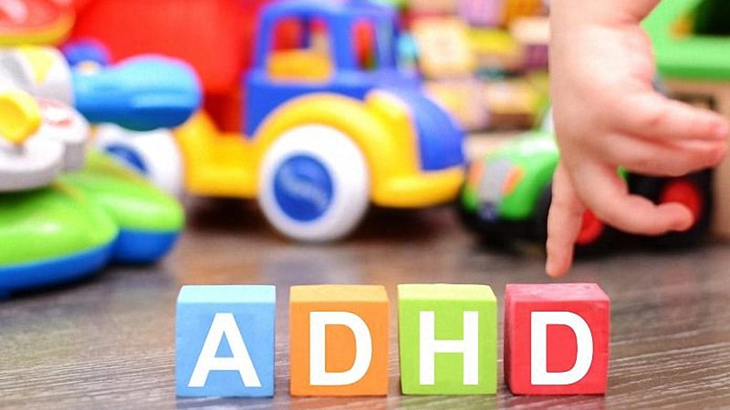 Multi-color cubes with letters that read ADHD with children's toys in the background