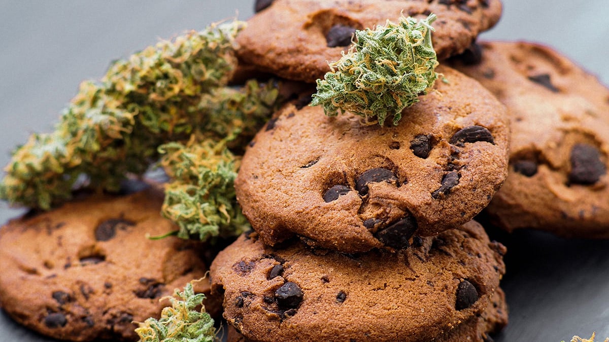 Image of multiple cookies with cannabis buds lying on top of each other