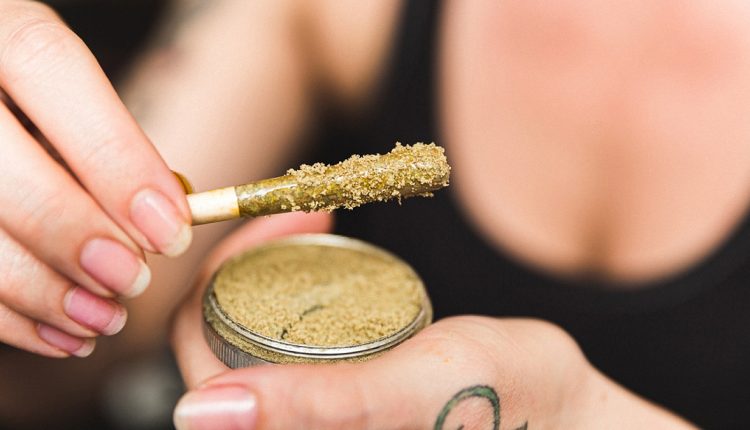 A woman holding a kief grinder