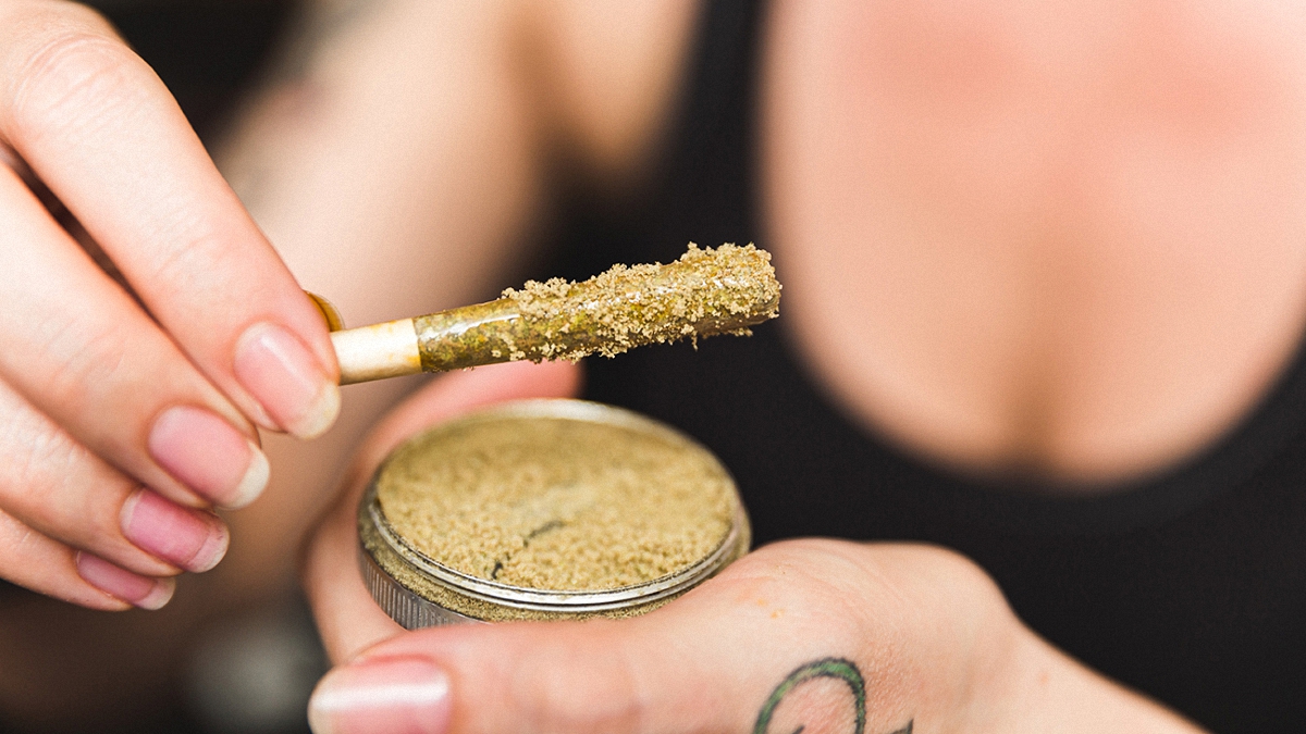 A woman holding a kief grinder