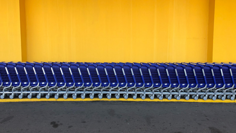 Shopping carts stocked near each other in front of a yellow wall