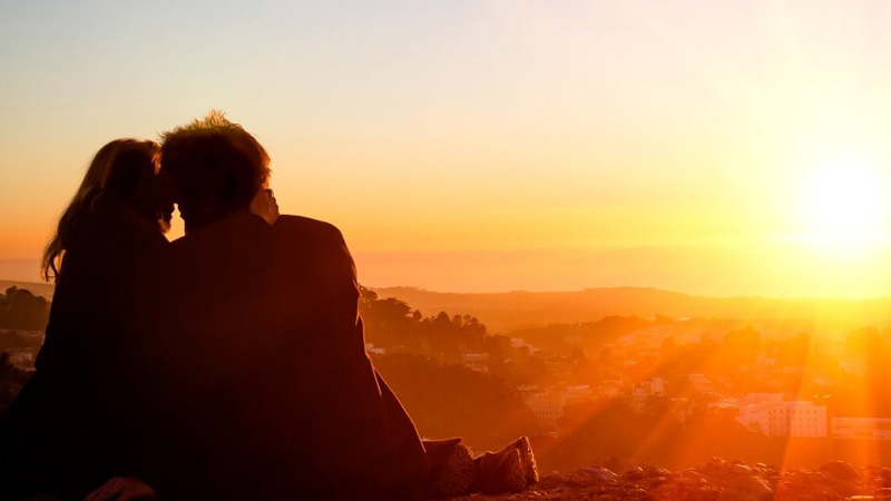 A couple in love sitting by the sunset 