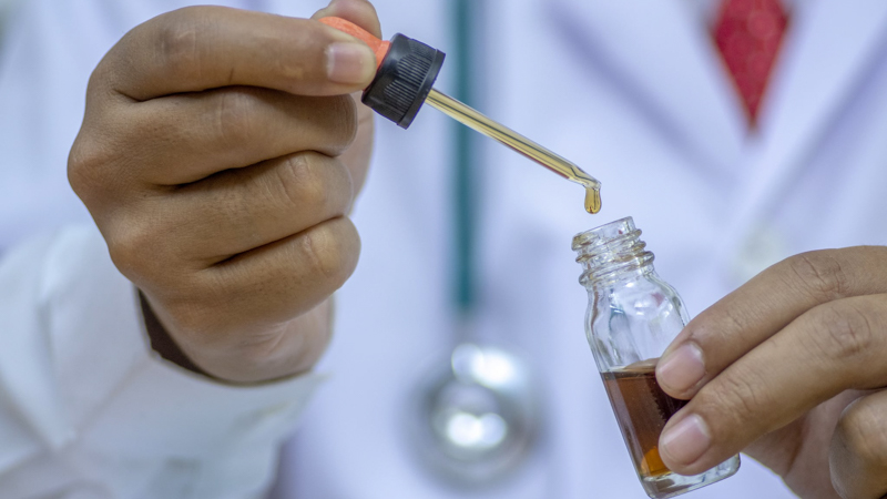 a doctor holding a cbd oil bottle