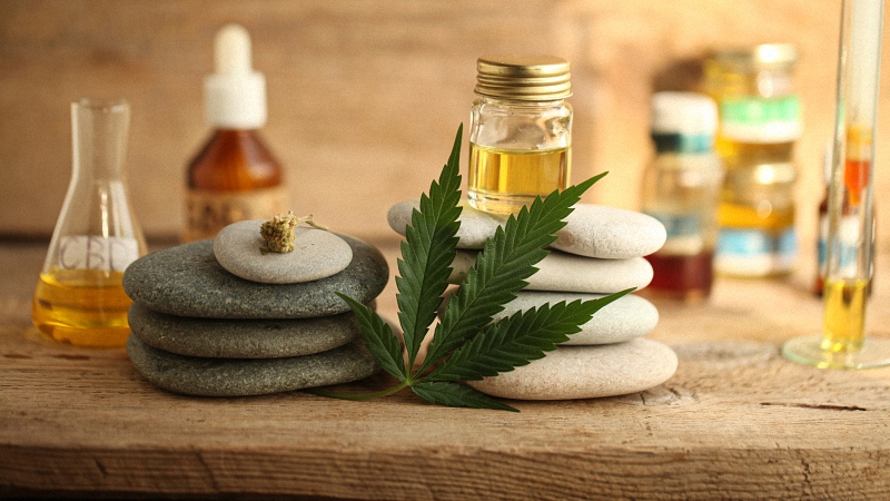 CBD Oil and Hemp Leaf on Rocks