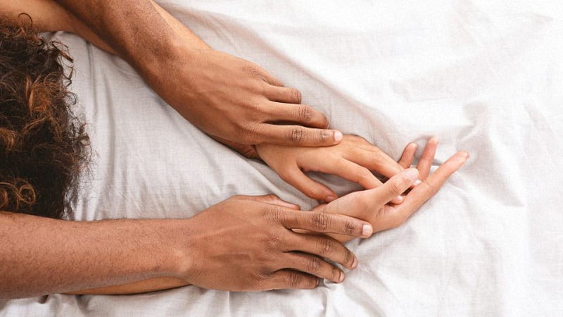 Couple's Hands in Bed