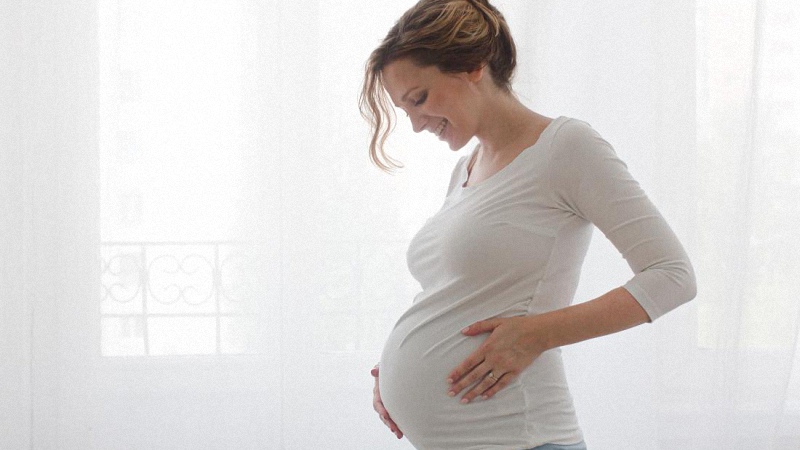 pregnant woman smiling with white background