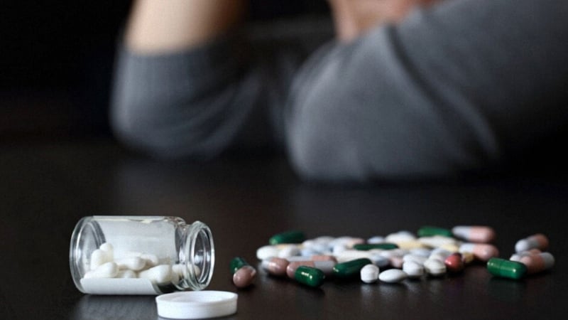 Spilled Capsules and Tablets with Anxious Woman Background