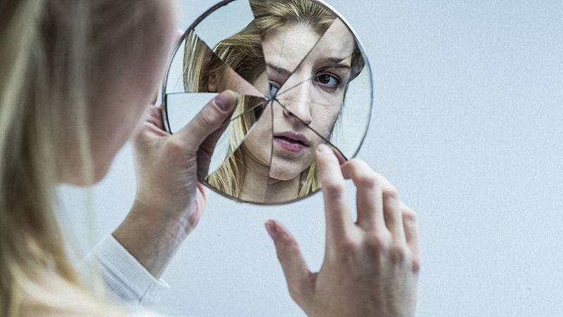 Woman with Bipolar Facing a Broken Mirror