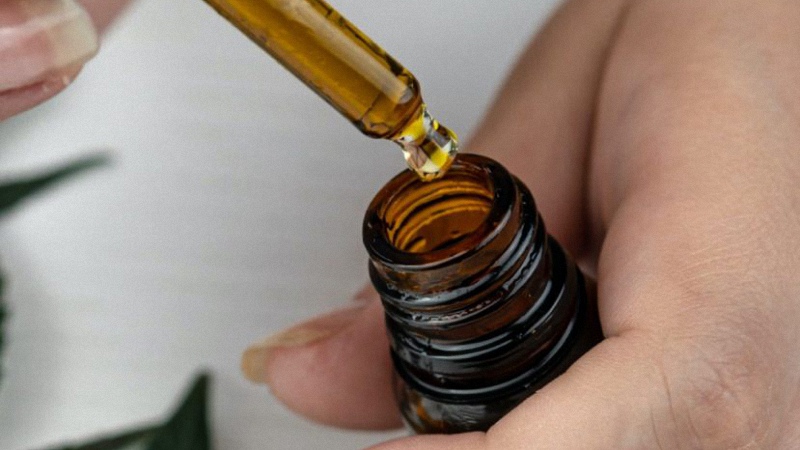 Hand Holds CBD Oil Dropper