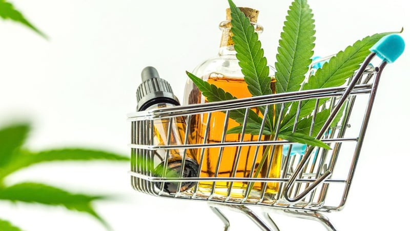 CBD Oil with Hemp Leaf on a Cart in White Background